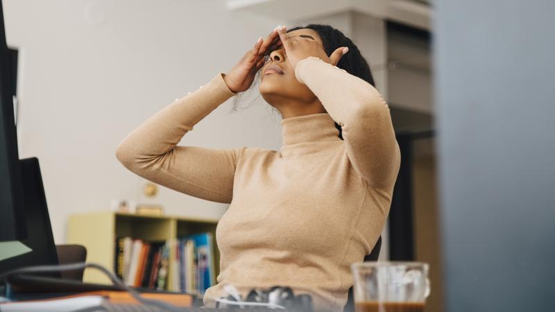 Stressed woman with her hands on her head