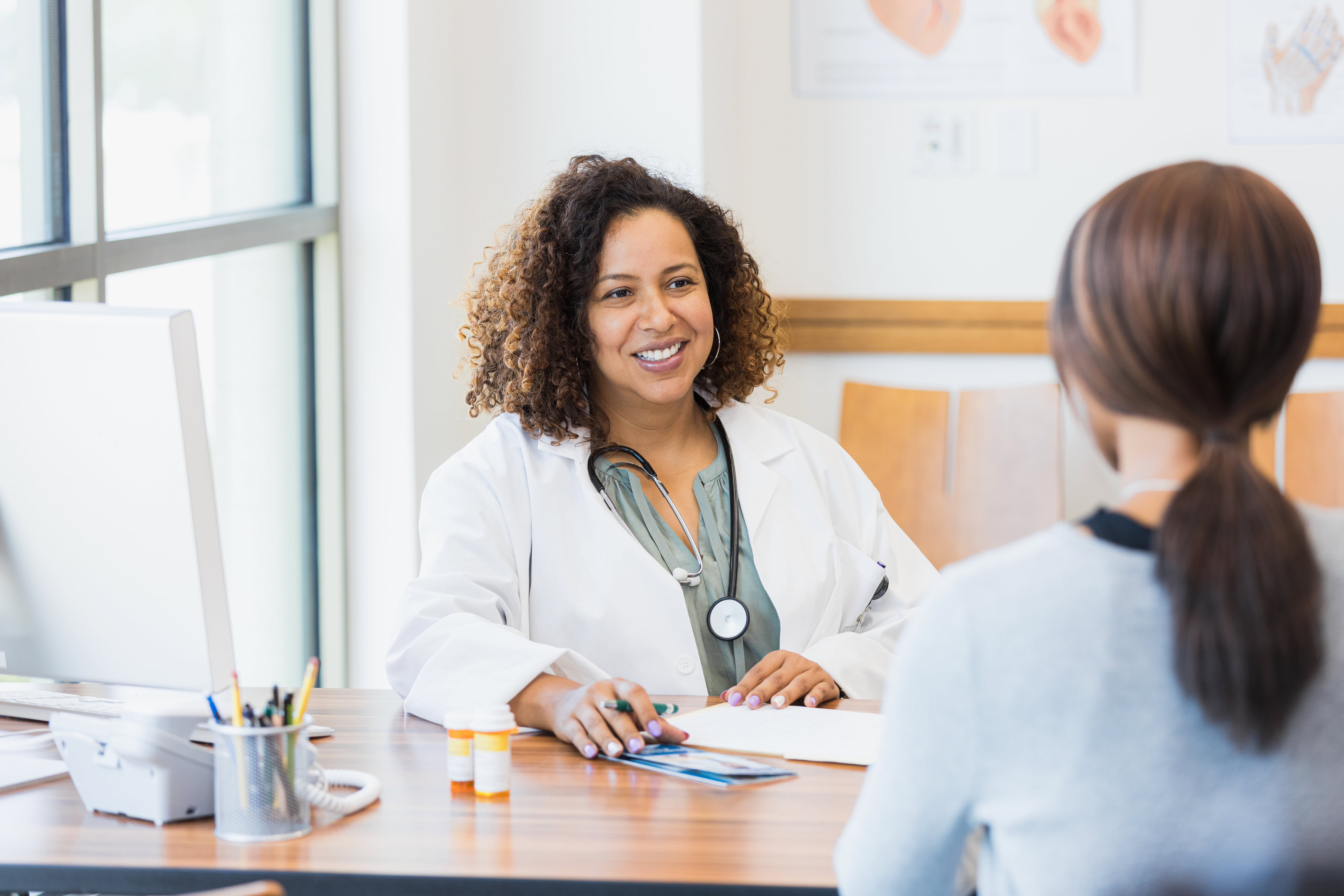 Female doctor listens with smile to senior patient
