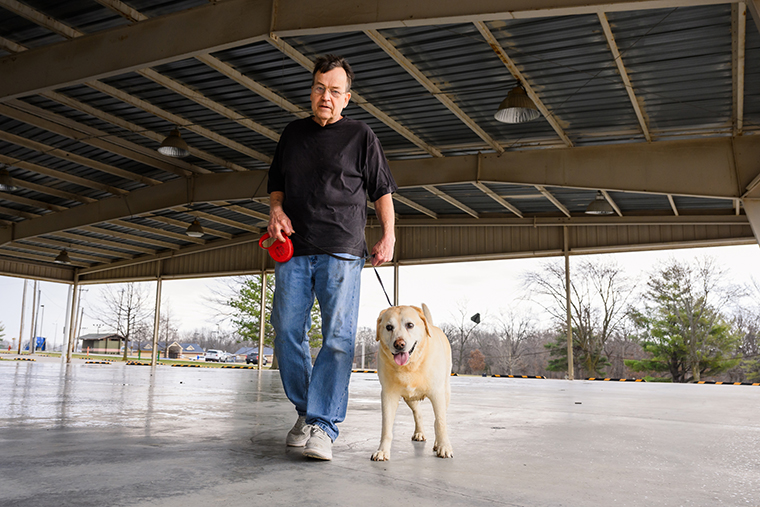 Randy and Bella walk together in a park in Moberly, Missouri, on March 6, 2026, more than a year after Randy finished treatment for multiple myeloma at MU Health Care’s Ellis Fischel Cancer Center.
