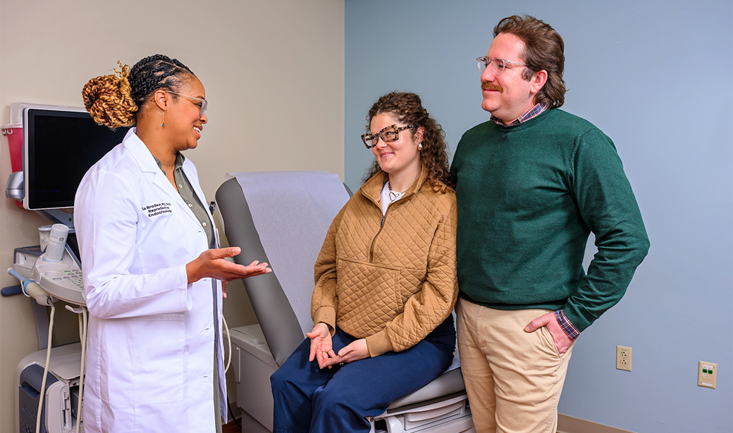 A physician speaks with a couple.