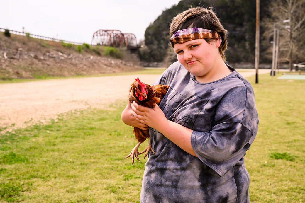 A photo of Caitlynn holding a chicken.