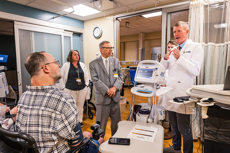 Toby Orcutt and his care team, including, from left, Jamie Basnett, FNP, Richard Barohn, MD, Brian Blankenship, MD, and W. David Arnold, MD, talk while Toby receives his second intravenous immunoglobulin infusion in June of 2026 in Columbia.