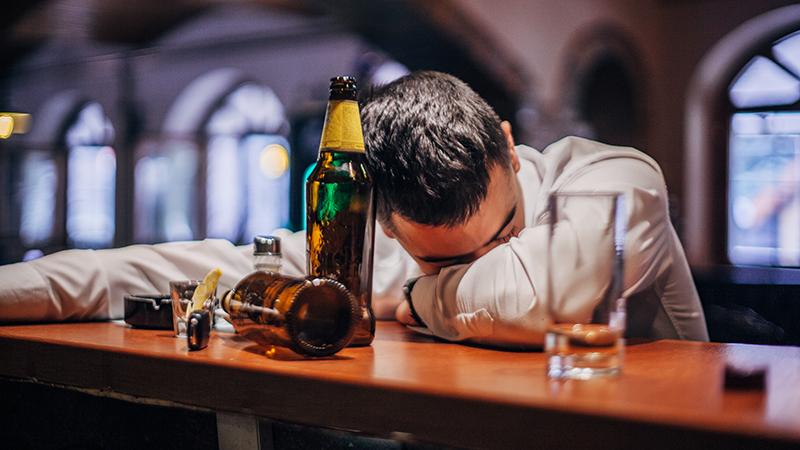 man asleep at a bar