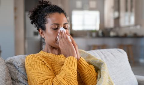 A woman blowing her nose.